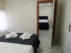 A hotel room with a bed, a nightstand, and a door leading to another room. - King Mas Suit (Istanbul)