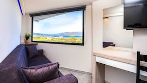 A modern room with a large window offering a scenic view of a coastal landscape. - Relax in Style at Ben’s Homes Panorama (Nopigia)