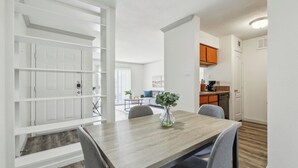 A modern kitchen with white cabinets, a wooden countertop, and a built-in oven.
