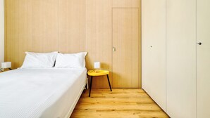 A bedroom with a bed, bedside table, and wardrobe. - 1-Bed apartment with balcony near subway (Milan)