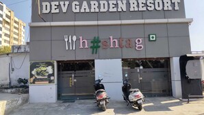 L’extérieur du Dev Garden Resort, avec une enseigne indiquant le nom du restaurant et le numéro de téléphone à contacter.
