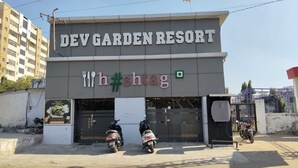 Un bâtiment portant l’inscription « DEV GARDEN RESORT » et affichant un panneau avec un symbole de hashtag.