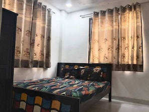 Une chambre à coucher avec un lit, des rideaux et une fenêtre.