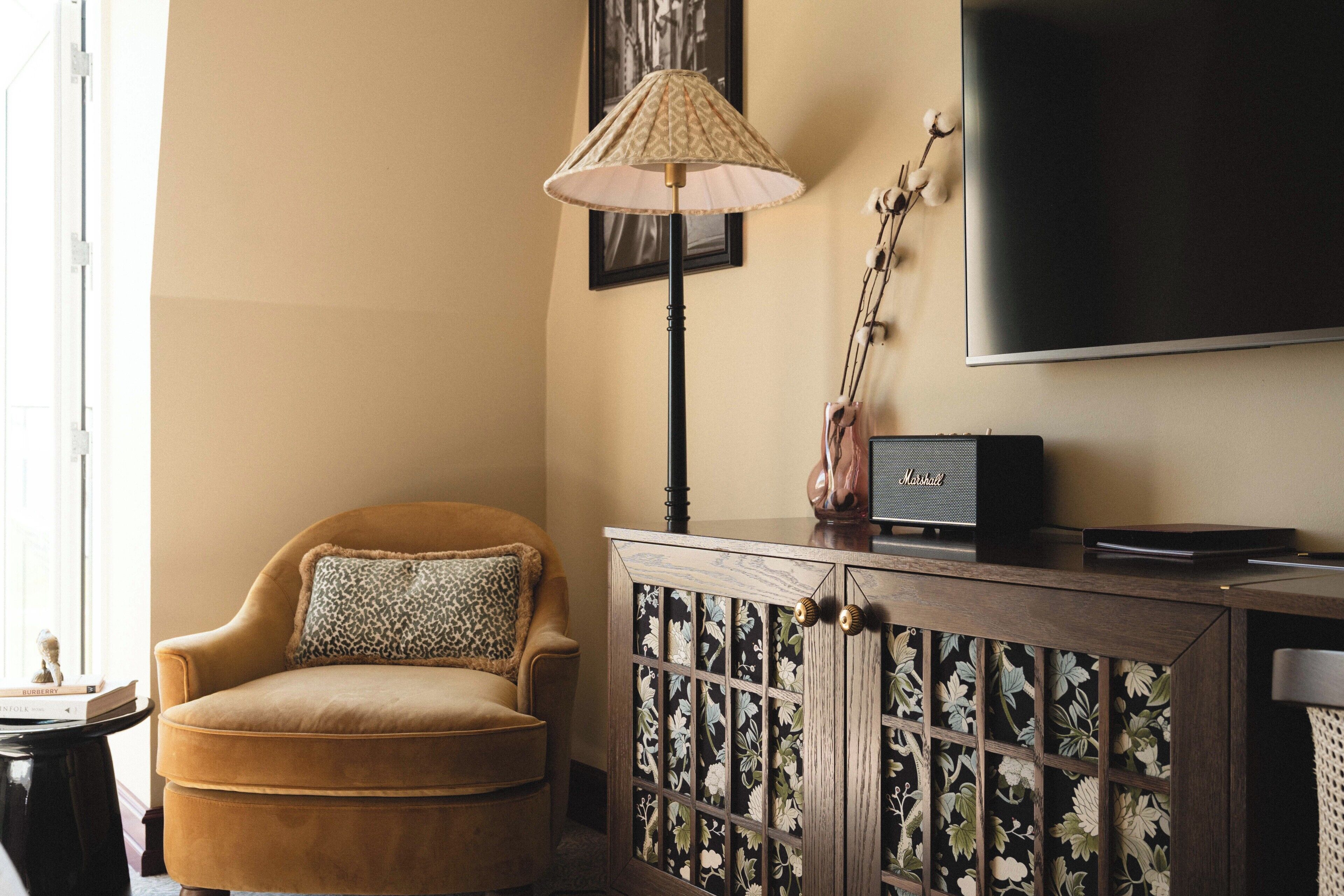 Ein Wohnzimmer mit einer Couch, einer Lampe, einem Fernseher und einem Schrank.