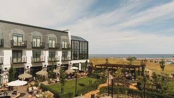Um hotel com várias varandas, área de estar externa e vista para o mar.