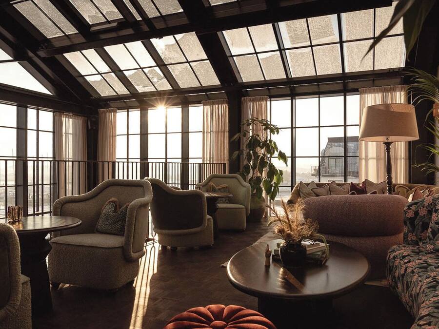 A spacious lounge with large windows, comfortable seating, and a ceiling with skylights.