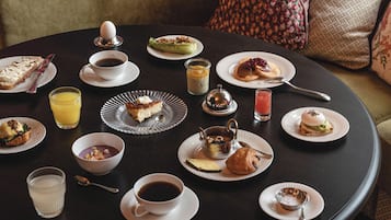 A round dining table with various breakfast items and beverages.
