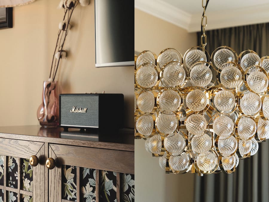 A wooden cabinet with a decorative lamp, a framed picture, and a Marshall speaker.