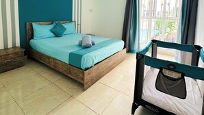 Ein Schlafzimmer mit Bett, einem Vorhangfenster, einer Wand-Klimaanlage und einem kleinen Nachttisch.