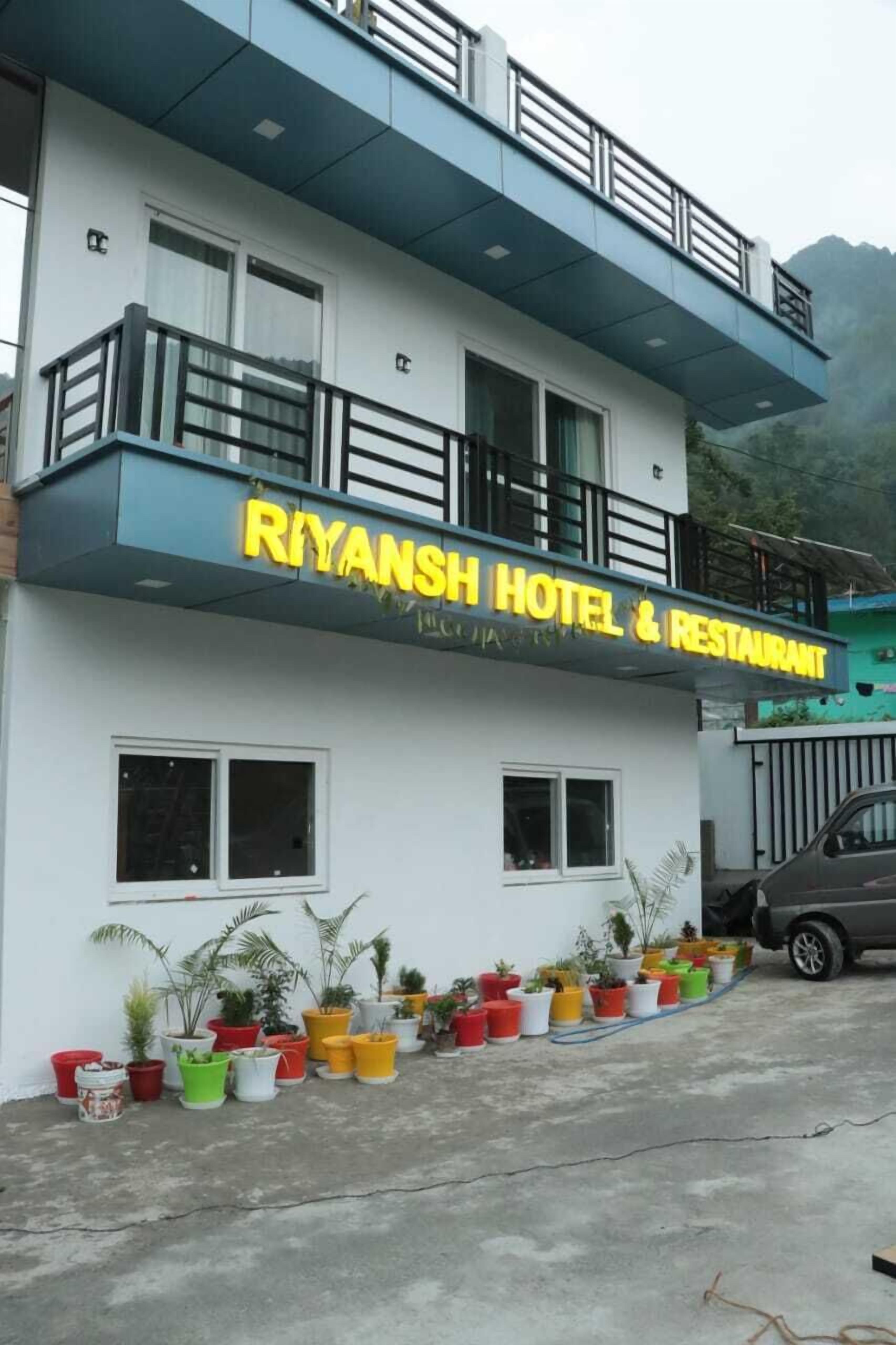 Un hotel con balcón y un letrero que dice "RIYANSH HOTEL & RESTAURANT".