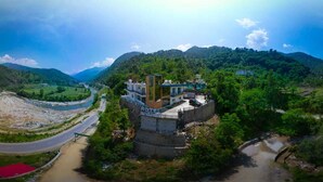 A hotel with a central courtyard, surrounded by lush greenery and hills. - Hotel Riyansh  (Ukhimath)