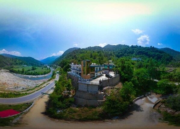 A hotel with a central courtyard, surrounded by lush greenery and hills. - Hotel Riyansh  (Ukhimath)