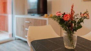 A dining table with a vase of flowers.