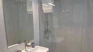 A modern bathroom with a white sink, a mirror, and a glass-enclosed shower area. - Charming studio in enchanting Bečići with AC, WiFi (Bečići)