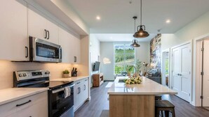 A modern kitchen with stainless steel appliances, a wooden island, and pendant lighting. - Apres Ski | DT | MtnView | TopFloor | AC | Sleep 6 (Golden)