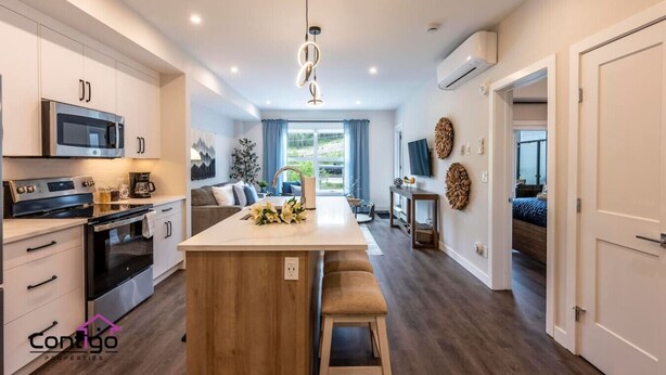 A modern kitchen with a central island, built-in appliances, and a dining area.