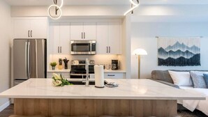 A modern kitchen with a central island, stainless steel appliances, and a minimalist design.