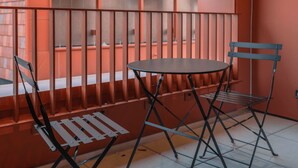 A small balcony with a metal table and two chairs. - Genius: An exceptional residence in Besançon in the heart of the Viotte business (BESANÇON)