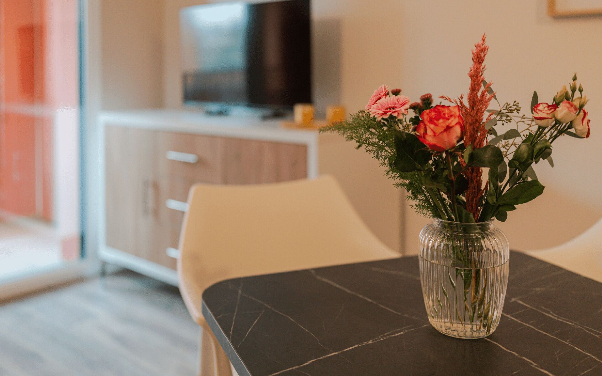 Ett matbord med en vas med blommor.
