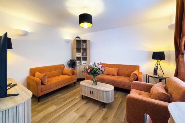 Stylish Social Lounge – This inviting space boasts bold burnt-orange sofas, warm wooden flooring, a Smart TV with Sky, and colourful accents that brighten the space.