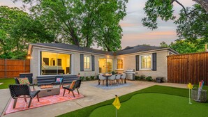 A backyard with a patio, outdoor seating, a grill, and a flag on a golf tee. - The Lyndzee-Luxury Downtown Haven, Pool, Sleeps 16 (Dallas)