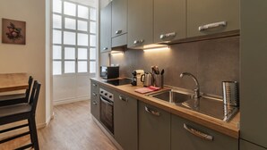 A modern kitchen with grey cabinets, a wooden countertop, and a stainless steel sink. - CS Termini National Apt No. 3 (Rome)
