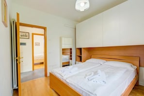 A bedroom with a wooden bed, a wardrobe, and a mirror. - Boutique Terrace Apartment In The Center (Riva del Garda)