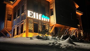 A building with a sign that reads "Elif Suite" at night.