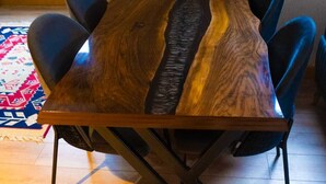 A rectangular wooden table with a unique grain pattern, surrounded by six chairs.