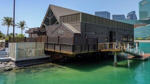 A waterfront building with a wooden exterior, a sloped roof, and a nameplate reading "fin". - Bloomfeilds Tranquil STU Al Maryah Vista (Abu Dhabi)