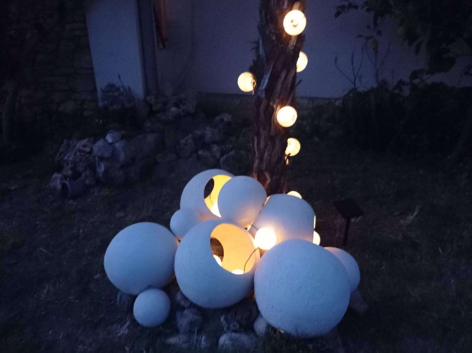 A tree with spherical lights arranged around it.