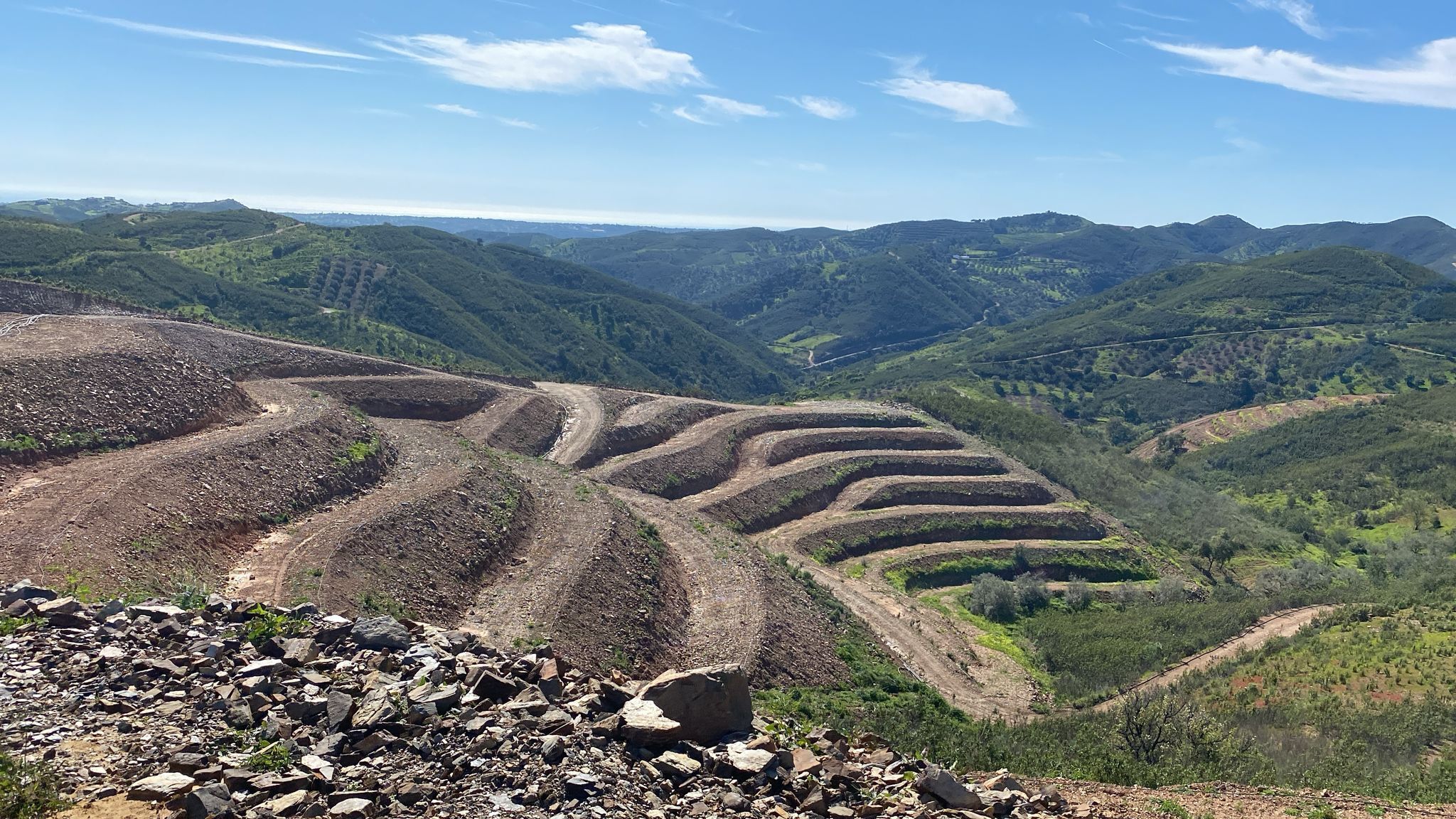 Campos agrícolas en terrazas con una vista despejada del paisaje montañoso circundante.