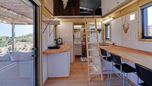 Une cuisine de taille réduite avec un comptoir en bois, une échelle et un évier.