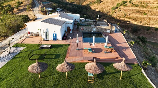 A modern house with a swimming pool, outdoor seating, and a well-maintained lawn. - Portugals Infinity Eco Suite Resort (Tavira)