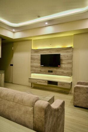 Un salon moderne avec un téléviseur à écran plat fixé à un mur en bois, un banc intégré et un canapé.