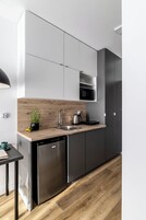 Una cocina moderna con encimera de madera, electrodomésticos de acero inoxidable y armarios grises.