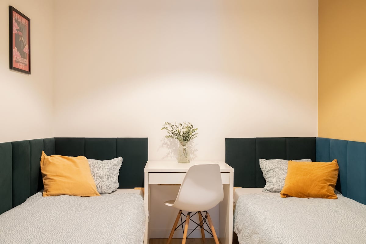 A room with two beds, a desk, and a chair.