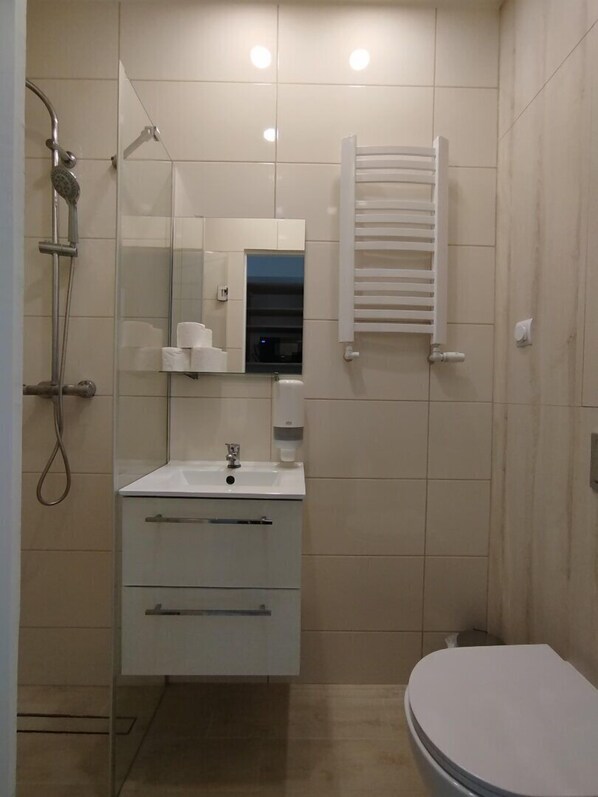Un baño moderno con ducha, inodoro y tocador.