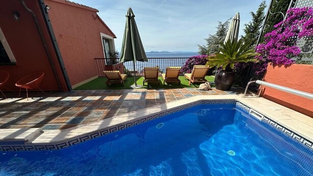 A swimming pool with a tiled deck, lounge chairs, and a view of the sea. - Exceptional villa with panoramic sea views AV 81 (ROSES)