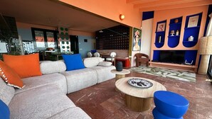 A modern living room with a sectional sofa, a round coffee table, and a TV. - Exceptional villa with panoramic sea views AV 81 (ROSES)