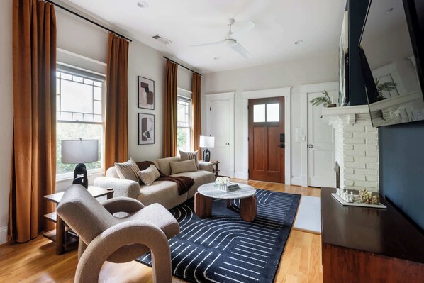 A spacious living room with a sofa set, a coffee table, and a fireplace.