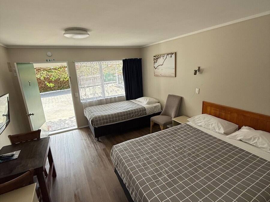 Una habitación de hotel con dos camas, un escritorio y una silla.