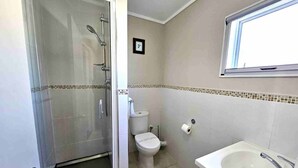 Un baño con ducha de vidrio, inodoro y bañera.