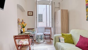 Habitación compacta con una mesa de comedor, sillas, un sofá y un ventanal con vistas.
