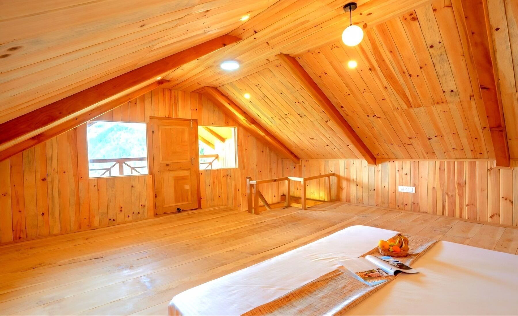 Ein geräumiges Schlafzimmer im Dachgeschoss mit Holzwänden und geneigter Decke.