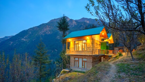 A mountain lodge with a balcony and a view of the surrounding mountains. - Ruhaani Cottages And Cafe (Banjar)