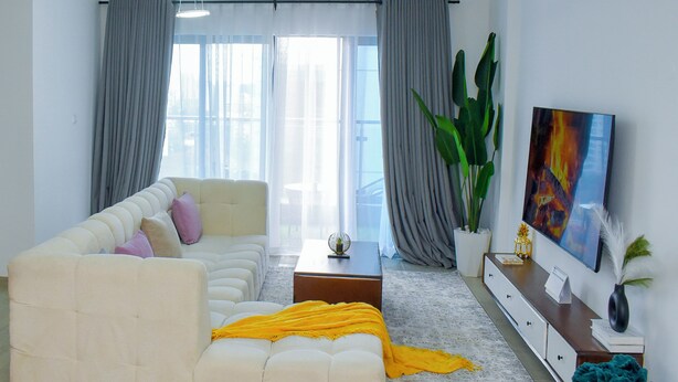 A modern living room with a sofa, coffee table, and a TV on a stand.
