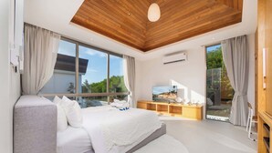 A modern bedroom with a large bed, a wooden ceiling, and a view of a beach through the window.