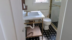 A small bathroom with a white sink, a toilet, and a shower. - King Room - K (Lake Placid)