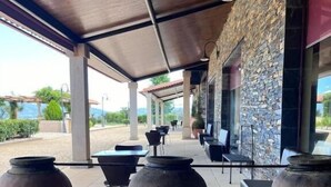 An outdoor patio area with stone walls, large ceramic pots, and modern furniture. - Tranca da Barriga by Quinta De São Tiago (Covilha)